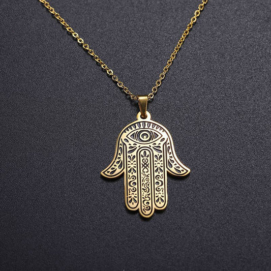 A gold-colored stainless steel Hamsa hand pendant with an evil eye design on a chain.