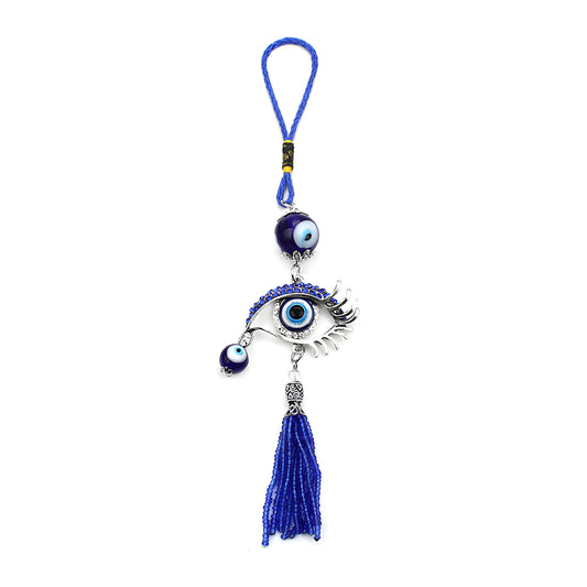 Handmade evil eye ornament hanging from car rearview mirror


