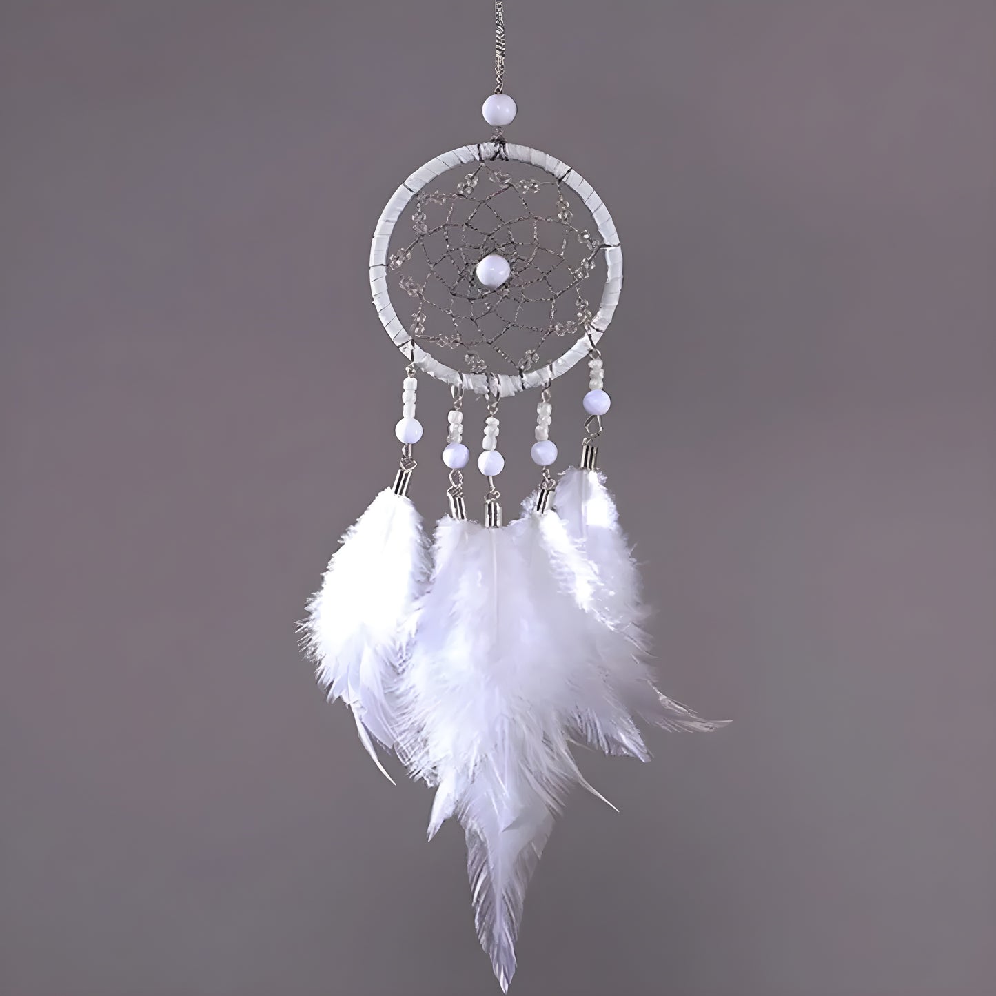 Handmade dream catcher charm hanging from car rearview mirror